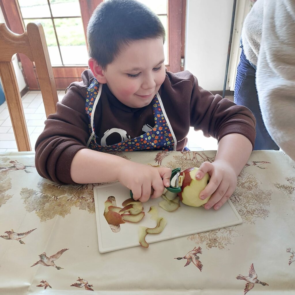 Une garçon qui épluche des pommes