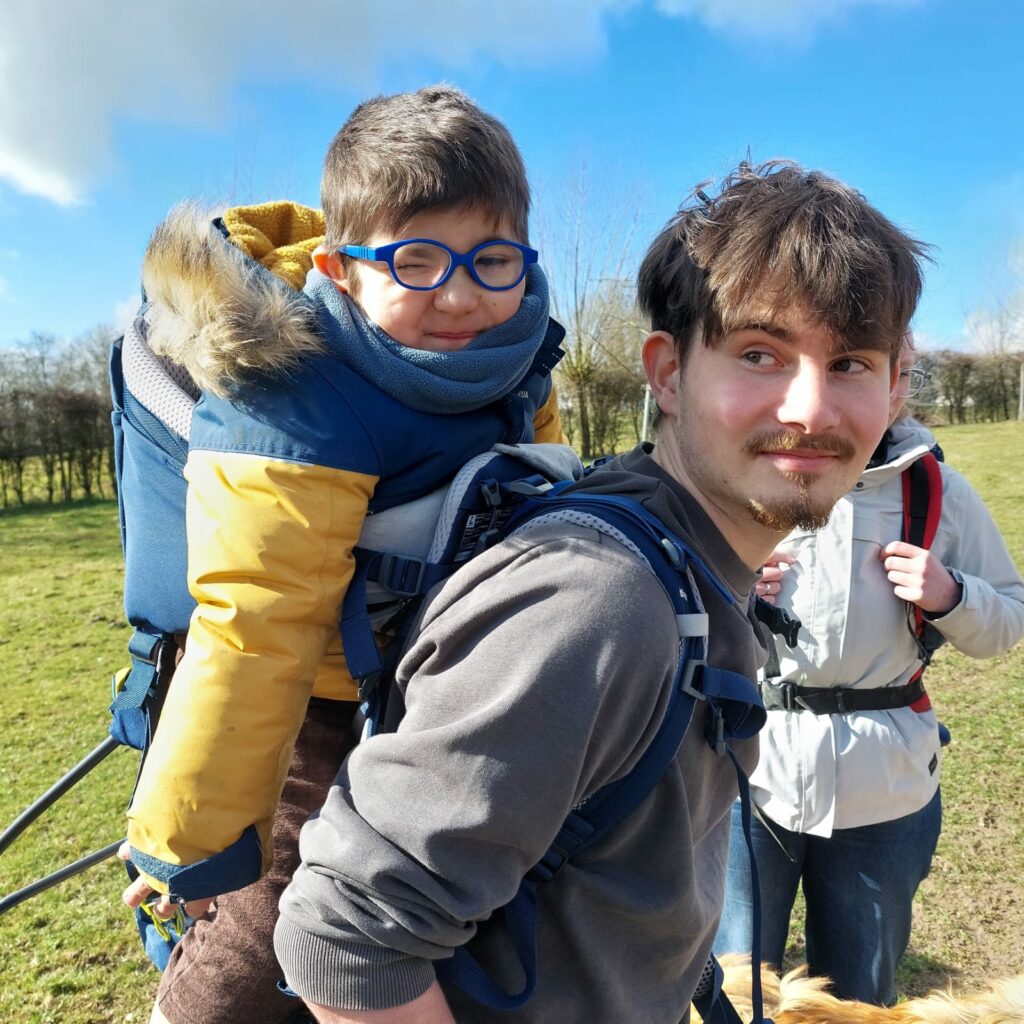 un jeune homme qui porte une petit garçon sur son dos