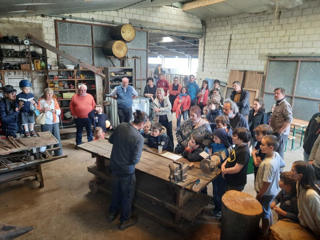 Une foule de gens qui regarde une démonstration de forge.