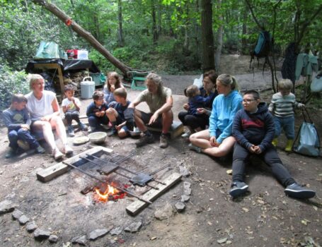 Des enfants et des adultes autour d'un feu de bois