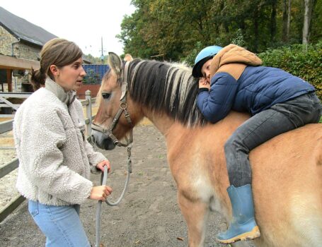 Un jeune enfant couché sur le dos d'un cheval