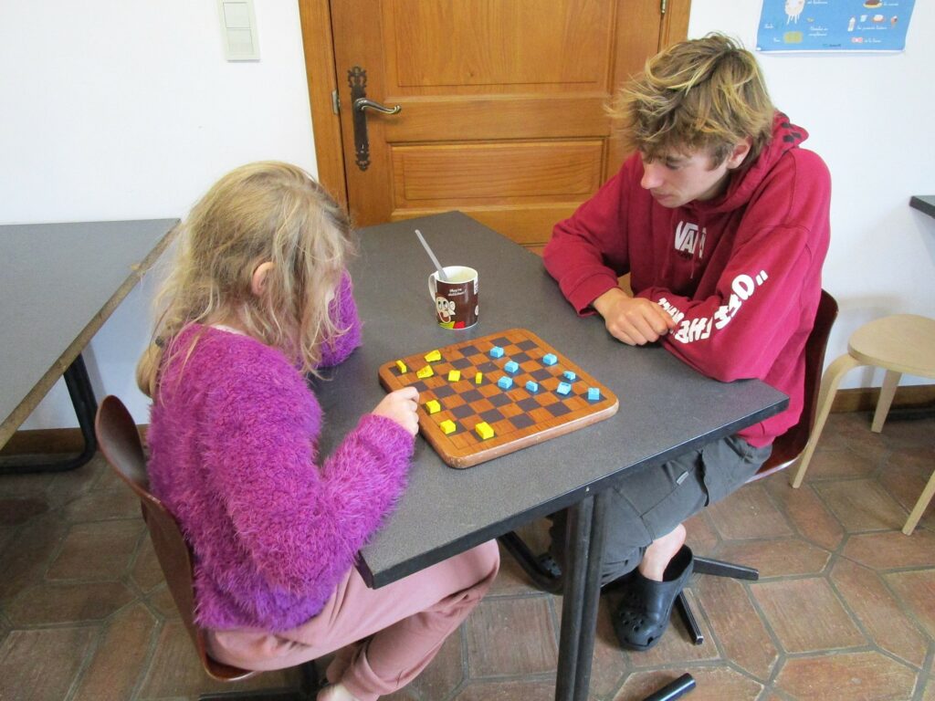 Basile qui joue à un jeu de société avec Elizabeth