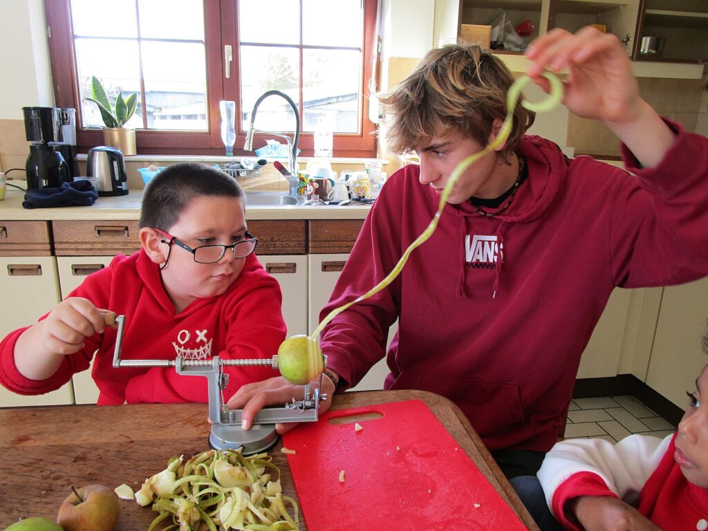 Ylenzo et Basile épluchent une pomme