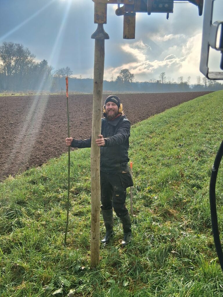 Cyril plante des tuteurs pour les arbres fruitiers