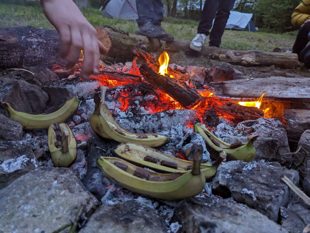 Bananes fourées de morceaux de chocolat qui cuisent sur un feu de bois