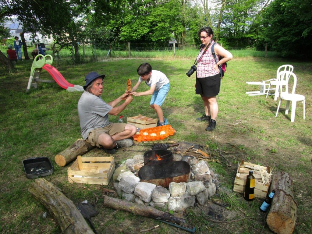 un adulte qui cuit des gaufres sur un feu de bois