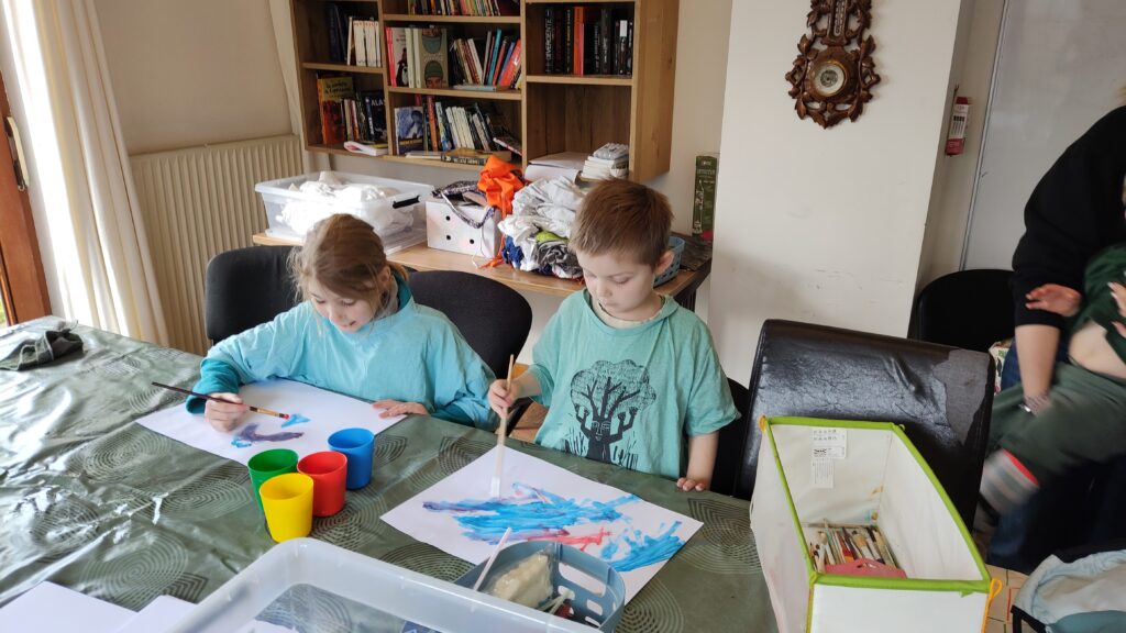 une petite fille et un petit  garçon qui font de la peinture